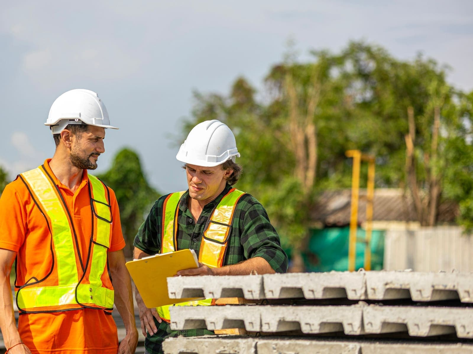 Two construction workers reviewing a plan together on site